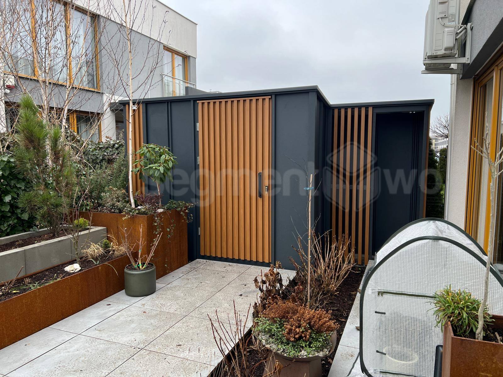 Domek narzędziowy z cofniętą drewutnią – blacha panelowa i lamele orzech, nietypowa bryła dopasowana do terenu